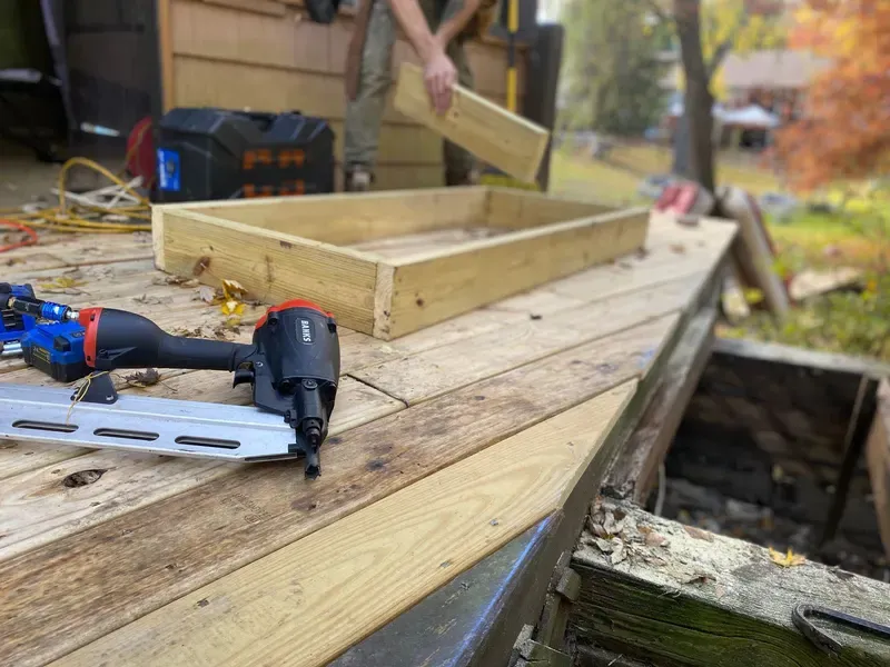 Pneumatic nail gun and a wood frame under construction on a deck