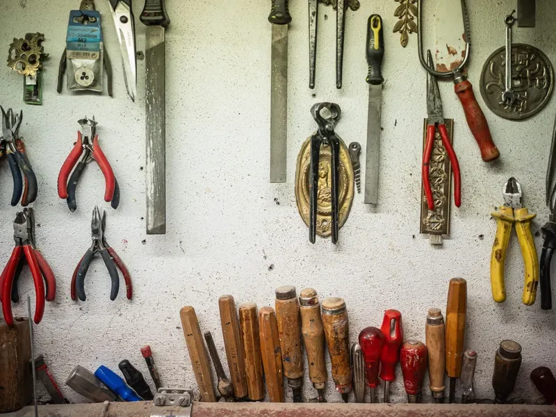 Wall of assorted hand tools hanging in a workshop